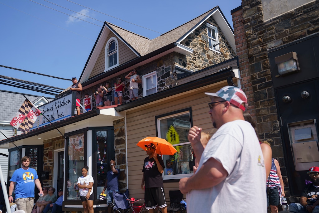 Viewers encourage the parade goers on the roof of Sunset Kitchen & Bath Inc. at the Fourth of July Catonsville Parade on July 4, 2025.