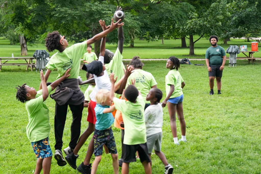 Camp counselor Isaiah Magruder, right, plays football with some of his campers during one of Camp St. Vincent’s youth activity sessions at Patterson Park in Baltimore, Md. on Wednesday, June 25, 2025.