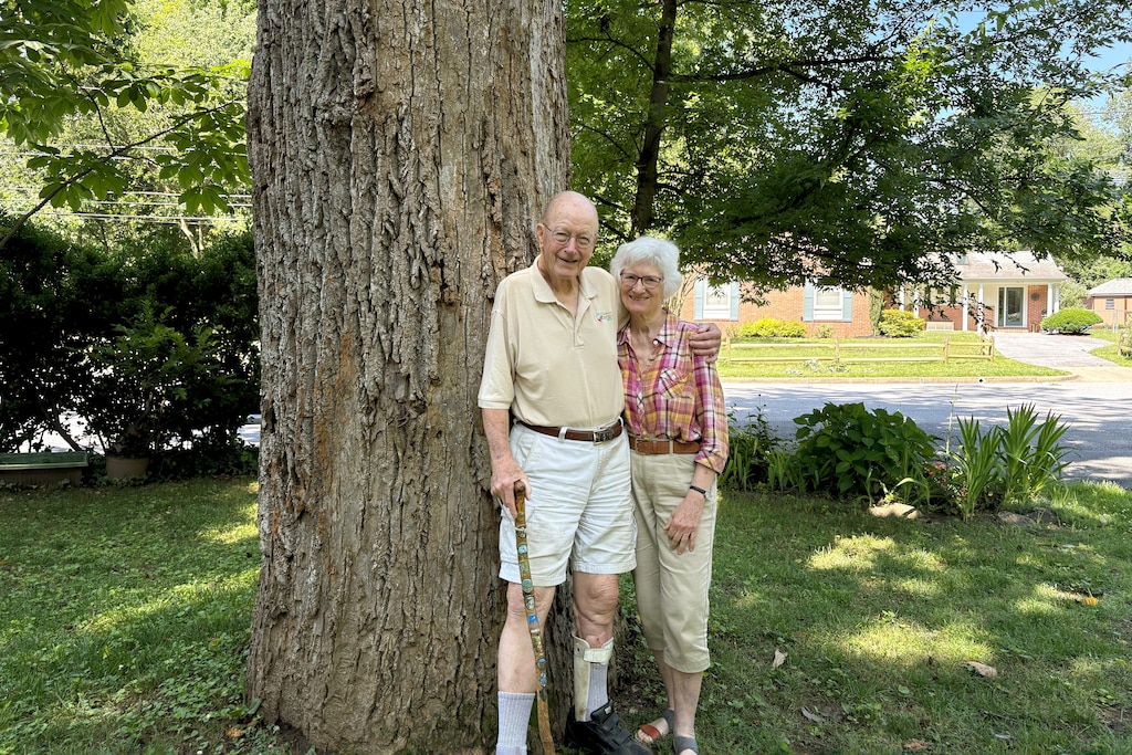Joe and Mary Howard, together since 1980, with a large tree at their home in Montgomery County.