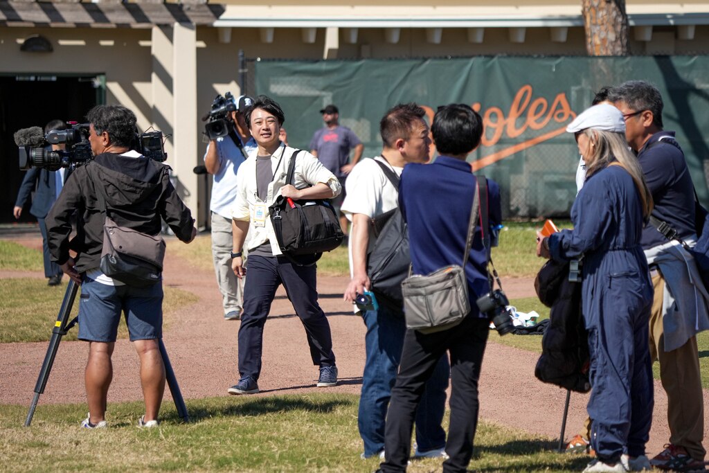 Journalists with various Japanese news outlets document newly signed Baltimore Orioles pitcher Tomoyuki Sugano as he warms up with the team during Spring Training at Ed Smith Stadium in Sarasota, Fla. on Sunday, February 23, 2025.