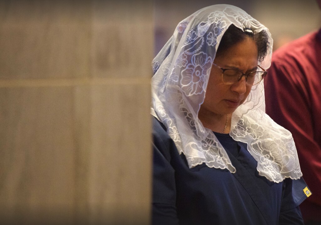 A parishioner wears a white veil that signifies reverence and a sign of submission to God during a Mass at the Cathedral of Mary Our Queen in North Baltimore on May 7, 2025.