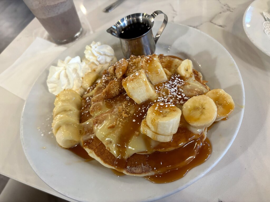 The banana pudding pancakes at JAM Eateries layered with fresh banana, homemade banana pudding, caramel, and vanilla wafers.