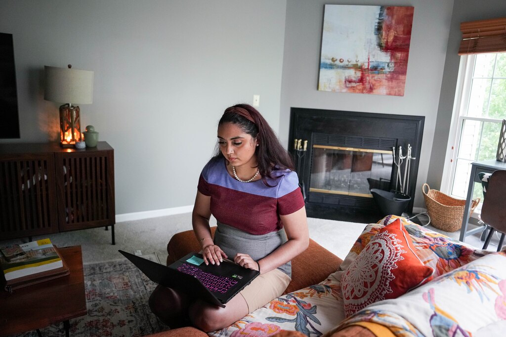 Tatyana Padro Miguel looks through job applications on her laptop in her Glen Burnie, Md. home after attending a Healthcare Employer career fair at Anne Arundel Community College earlier on Wednesday, May 21, 2025.