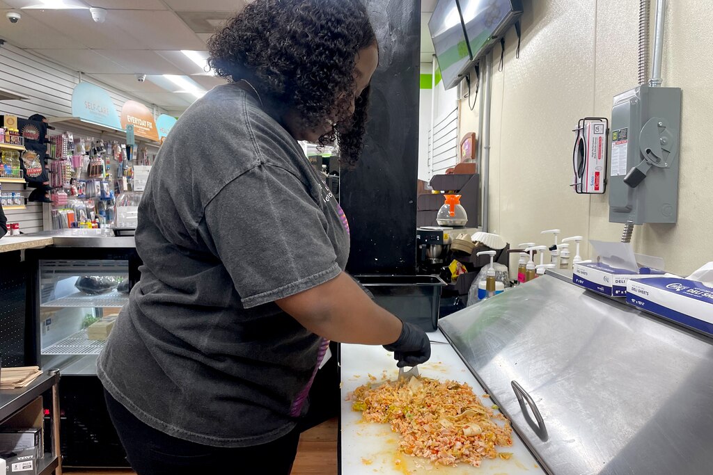 Jae Chambers prepares a chopped sandwich at Chopped in Fells Point, which offers sandwiches and affordably priced groceries to the community.