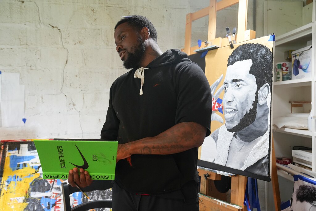 Waymond Harrison references Black artists, such as Virgil Abloh, and Black activists, such as Fred Hampton, the figure Harrison painted behind him as points of artistic inspiration. June 17, 2025.