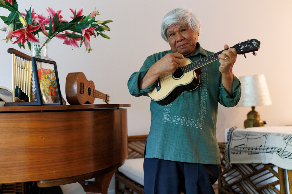 Jon Melegrito, 81, plays the ukulele at his home on Monday, June 30, 2025, in Clarksburg.