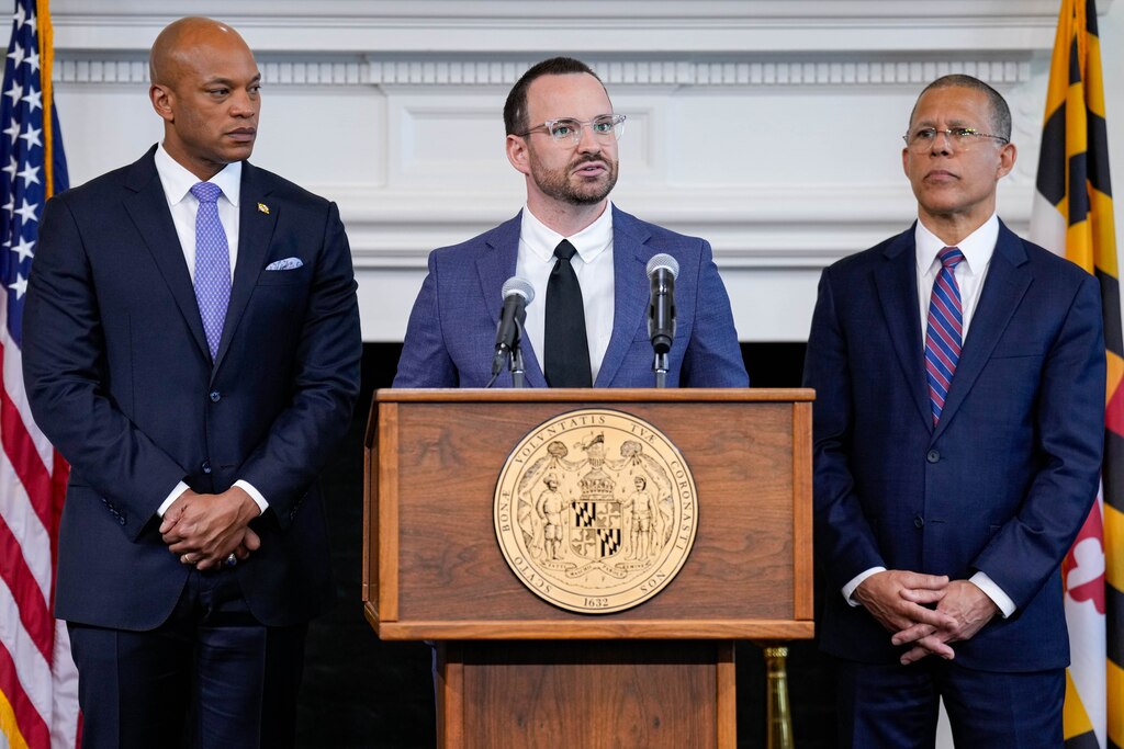 Dr. Jeff Kukucka, flanked by Gov. Wes Moore and Attorney General Anthony Brown, gives remarks on Maryland’s sweeping audit of police-custody deaths during a news conference at the Maryland State House in Annapolis, Md. on Thursday, May 15, 2025.