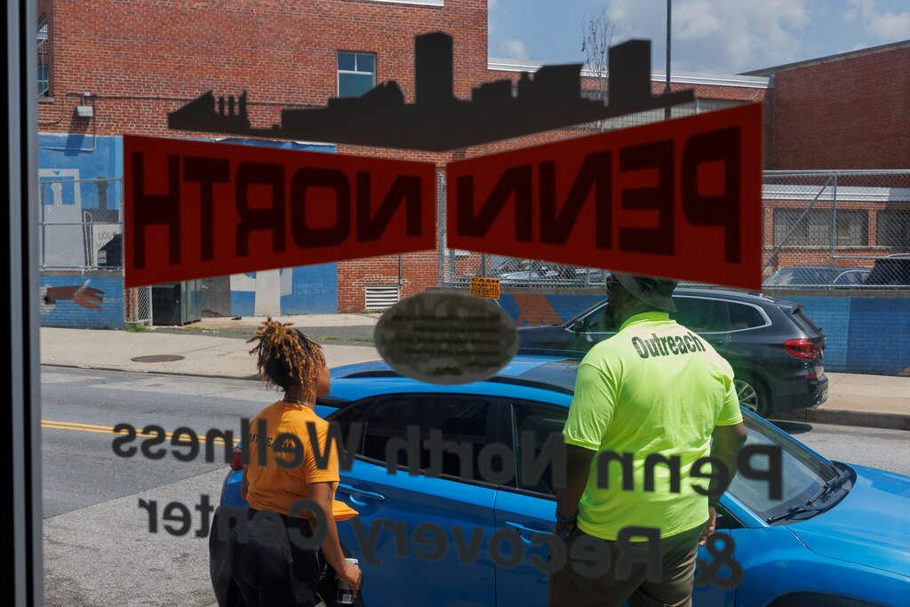 Erica McCloud and Sylvester Conn speak with community members outside of Penn North Recovery on Friday, July 11, 2025 in Baltimore. Just a day following a mass-overdose in the area.