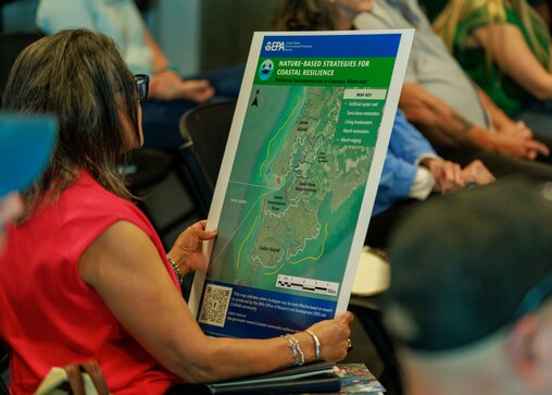 An attendee of the EPA's Crisfield Resilience Academly looks at a map featuring nature-based strategies for coastal resilience on April 26, 2025 at the Crisfield Library in Crisfield, MD.