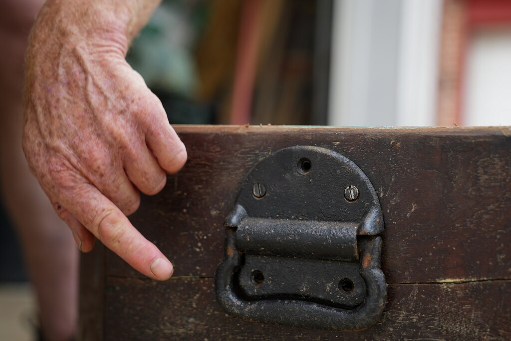 Artist Ashley Kidner points to a handle on the outside of Mathilda Lorenz’s empty casket outside his garage on July 28, 2022. The mysterious casket was originally found down by a stream in Wyman Park.