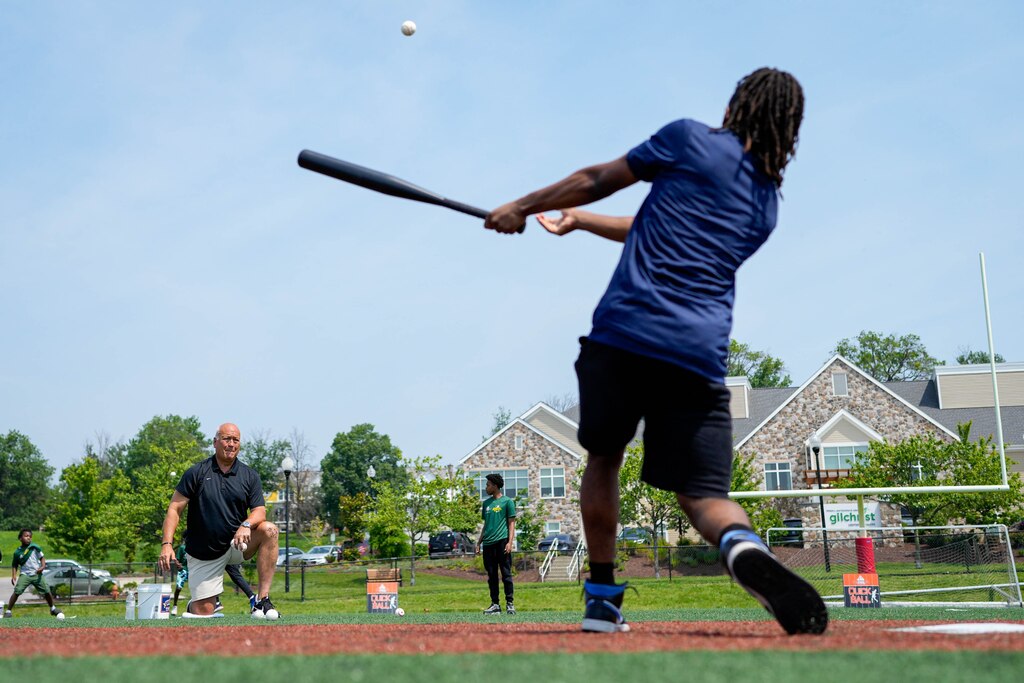 One of the James Mosher baseball players hits a pitch from Baltimore Orioles Hall of Famer and minority team owner Cal Ripken Jr. during a baseball clinic at Stadium Place, former site of Baltimore Memorial Stadium, in Baltimore, Md. on Thursday, June 12, 2025. Cal Ripken Jr., along with the Cal Ripken Sr. Foundation and MLB’s Nike RBI program, launched an initiative Thursday to expand access to the sport for youth around the country.