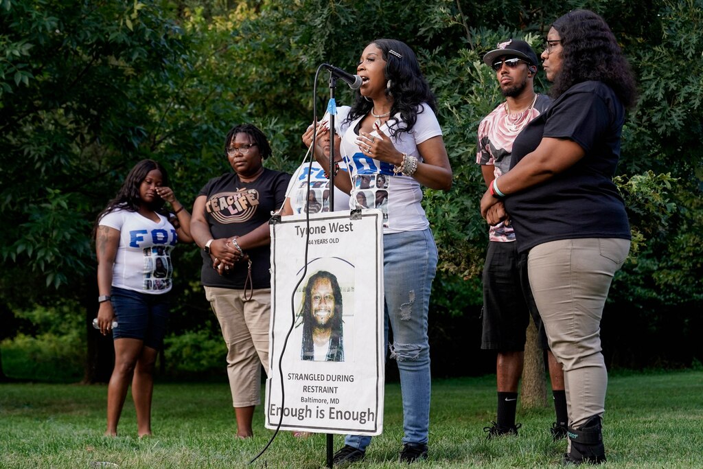 Tawanda Jones, sister of Tyrone West, speaks with members of the West Coalition behind her at the ten year anniversary memorial gathering to honor Tyrone West held on the corner of Kitmore Road and Kelway Road on July 18, 2023. West was killed after being pursued by two officers of the Baltimore Police Department after he fled a traffic stop in 2013.