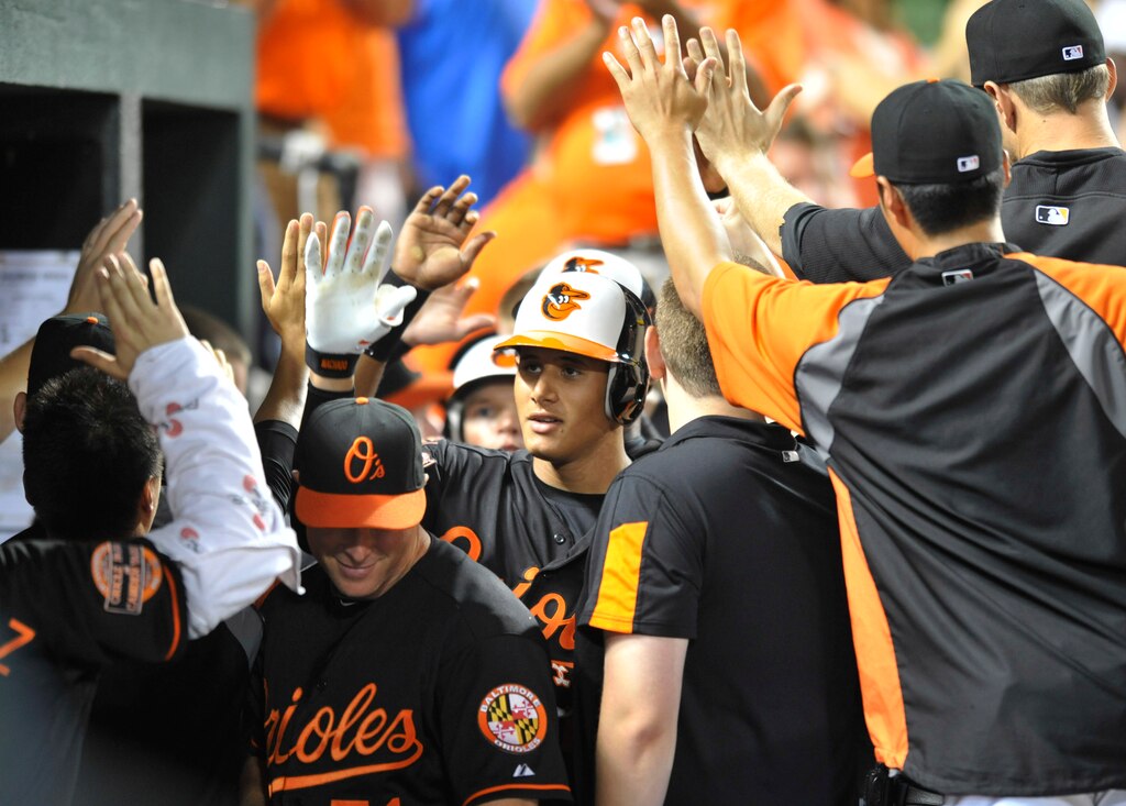 Baltimore Orioles' Manny Machado, center, is congratulated by the team after hitting a three-run home run against the Kansas City Royals in the sixth inning of a baseball game Friday, Aug. 10, 2012, in Baltimore.