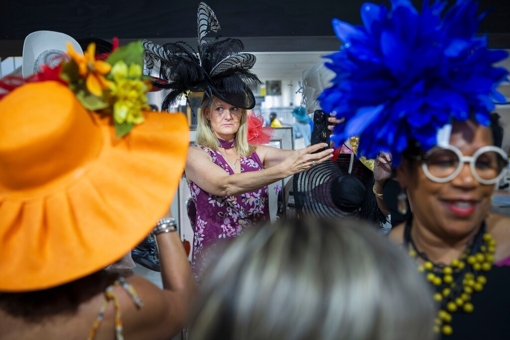 Laura Wilkins takes a selfie while trying on hats on Black Eyed Susan Day at Pimlico Race Course in Baltimore, Maryland, on Friday, May 17, 2024.