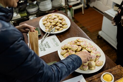 BALTIMORE, MD - DECEMBER 8, 2024: A visitor grabs a cookie inside the home of Melinda and Joe Mele on December 8, 2024 during the Annual Union Square Cookie Tour in Baltimore, Maryland.