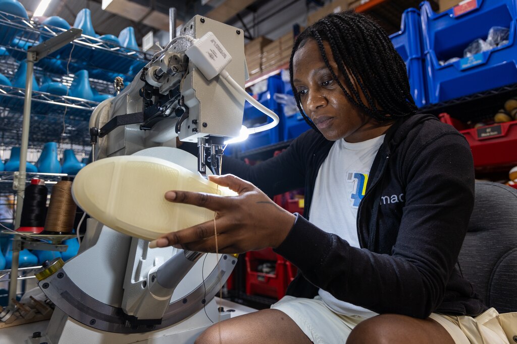 Kay Harding, Sew and Stitch Technician, working on cup sole stitching, which includes a giant needle going through the rubber soles of a shoe, in the Made Plus factory in Annapolis, MD on June 25, 2025.