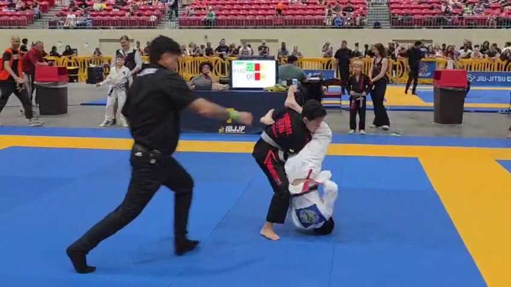 Mason Des Jardins, in white, performing a technique at the 2025 IBJJF Charlotte Summer Kids International Open in Concord, North Carolina. Photo courtesy of Paul Des Jardins