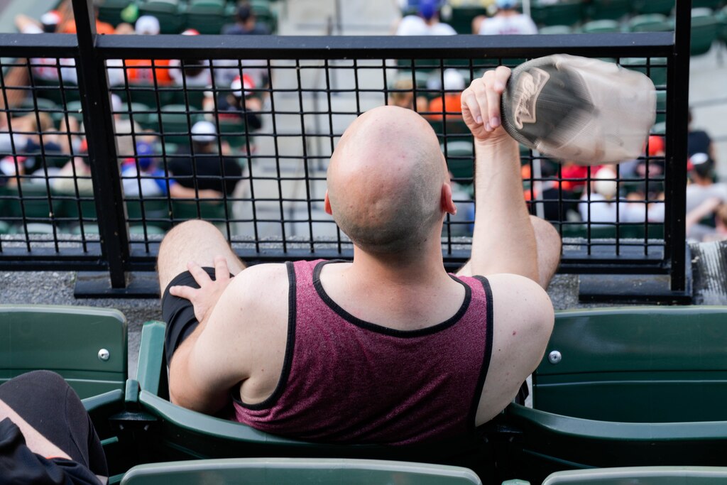 A Baltimore Orioles fan cools himself off with his hat during a game against the Texas Rangers at Orioles Park at Camden Yards in Baltimore, Md. on Monday, June 23, 2025.