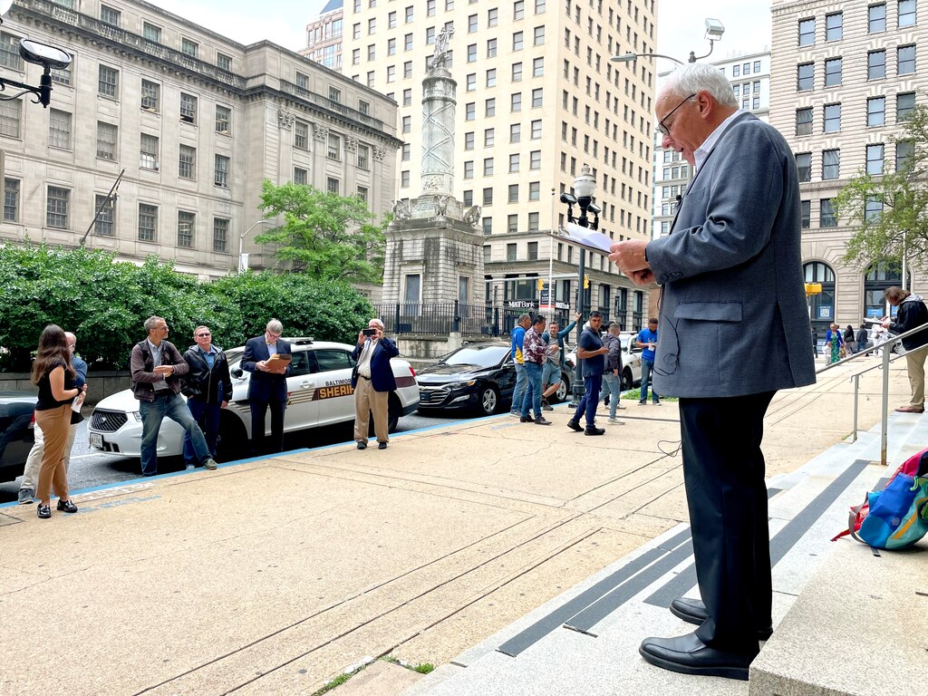 Paul Cooper of Alex Cooper holds auction of the former Bertha’s Mussels property on the steps of the Clarence Mitchell courthouse in Baltimore on Thursday, May 29, 2025.