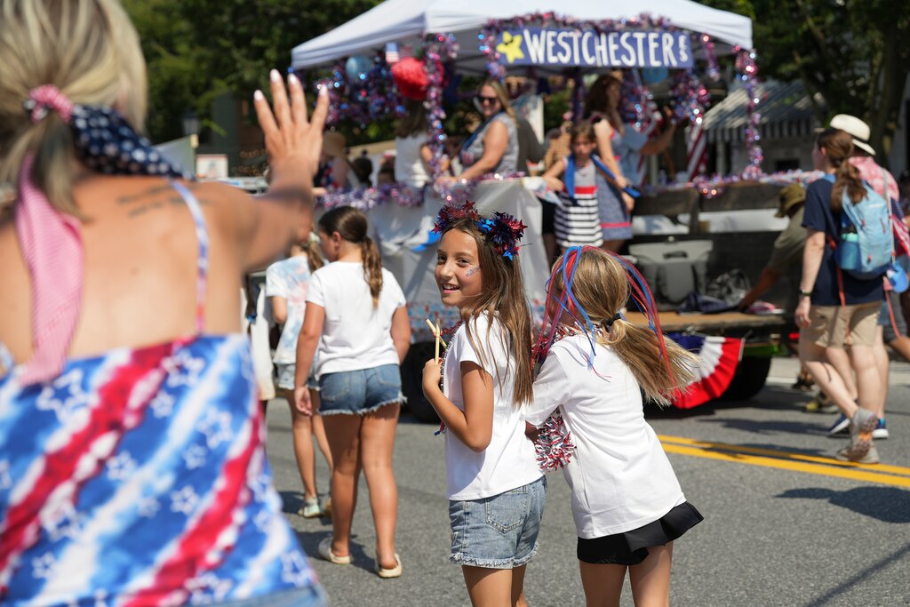 Children riding the Westchester Elementary School float jump off to say hi at the Fourth of July Catonsville Parade on July 4, 2025.