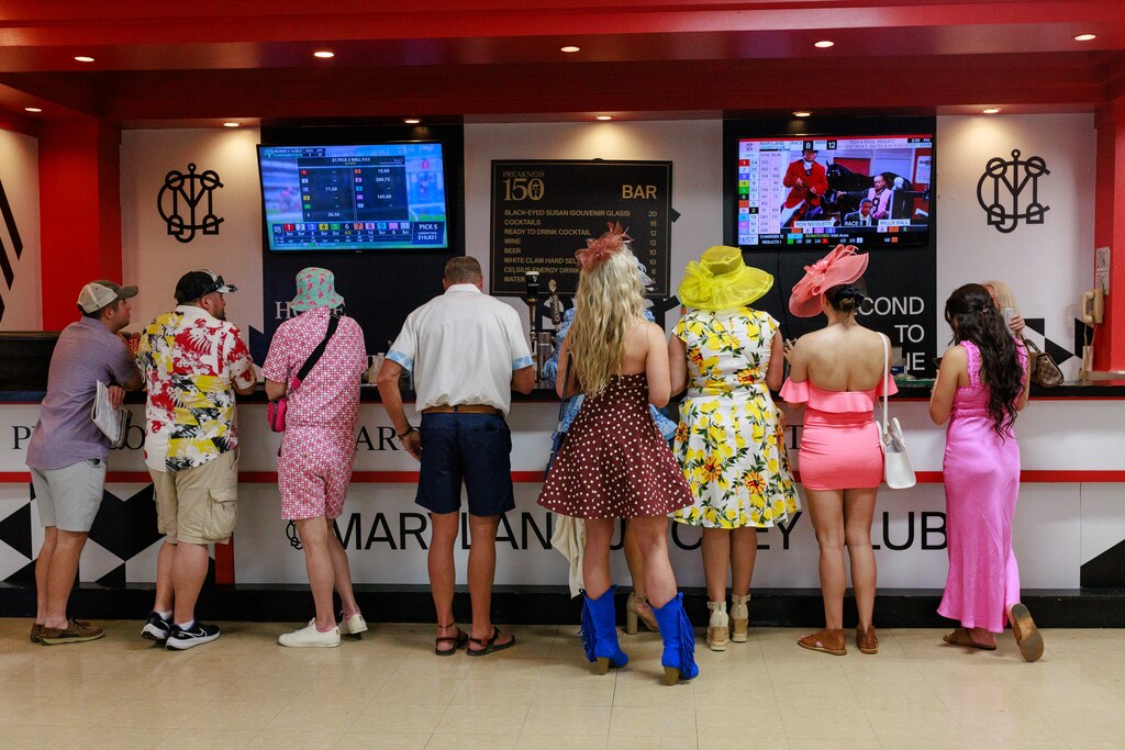 Attendees wait for a drink at the bar in the Clubhouse at The Preakness Stakes at Pimlico Race Course on Saturday, May 17, 2025, in Baltimore.
