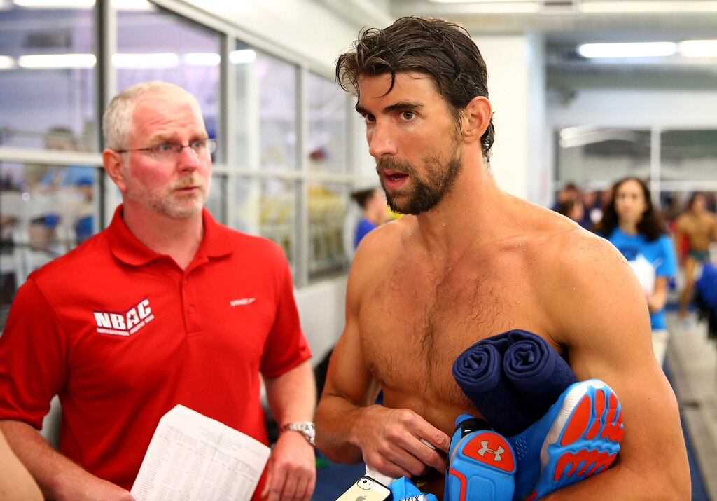 CHARLOTTE, NC - MAY 16: (L-R) Coach Bob Bowman and Michael Phelps talk after his swim in the men's 100m butterfly final during day 1 of the Arena Grand Prix at Charlotte at Mecklenburg County Aquatic Center on May 16, 2014 in Charlotte, North Carolina. (Photo by Streeter Lecka/Getty Images)