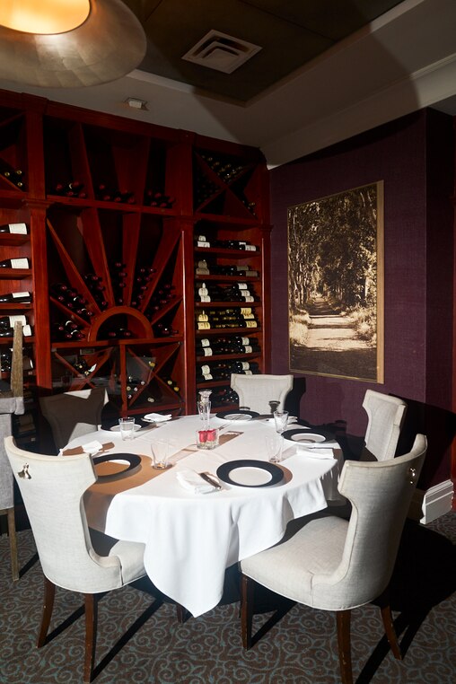 Tables found in the rear dining room a New American restaurant in Harbor East on Tuesday, June 24, 2025. Seats in this secluded room are highly sought after for their proximity to the wine shelf.
