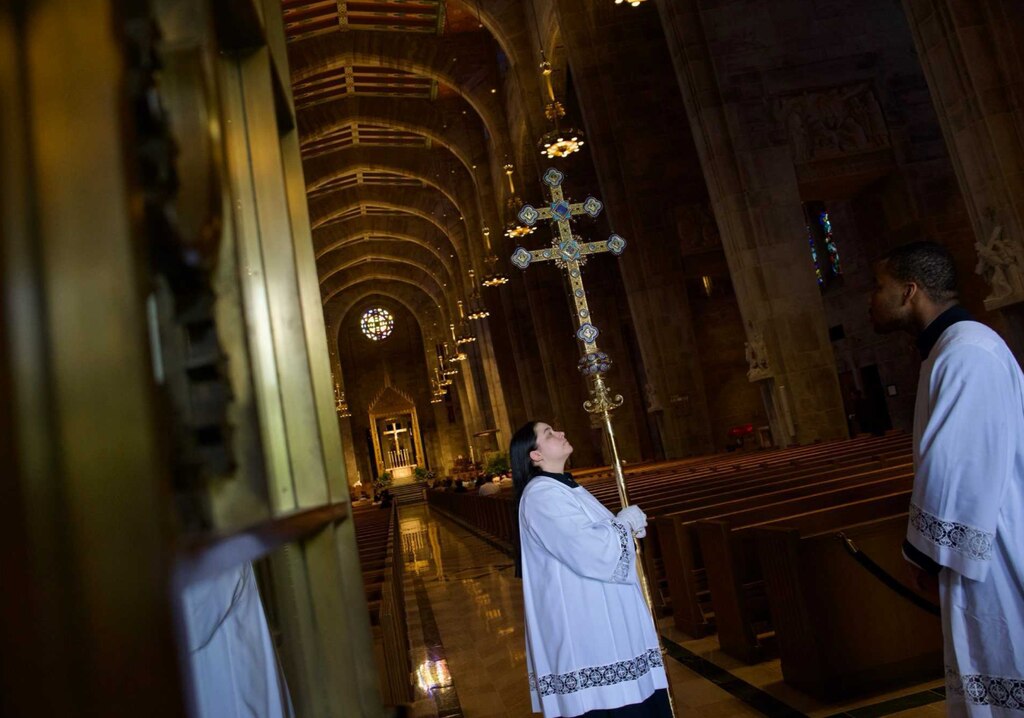 A cross bearer prepares to walk the cross down the aisle of the Cathedral of Mary Our Queen in North Baltimore on May 7, 2025.