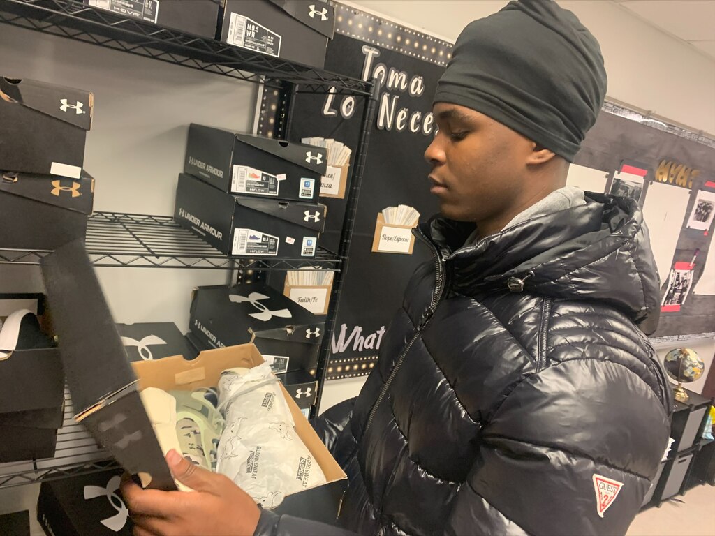 Justin Glod,15, looks at a pair of free shoes in a new community storefront sponsored by DTLR. The space is part of the Re-Engagement Center inside the Baltimore City Public Schools headquarters.
