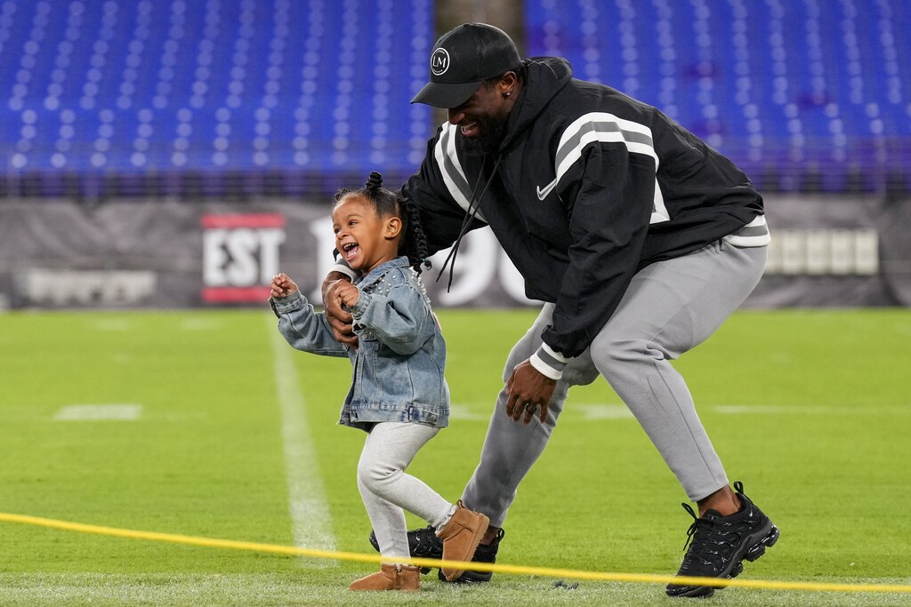 Baltimore Ravens running back Justice Hill chases after his two-year-old daughter, Ary, on the field during A Purple Evening, the Baltimore Ravens’s annual women’s event, at M&T Bank Stadium in Baltimore on Monday, October 14, 2024.
