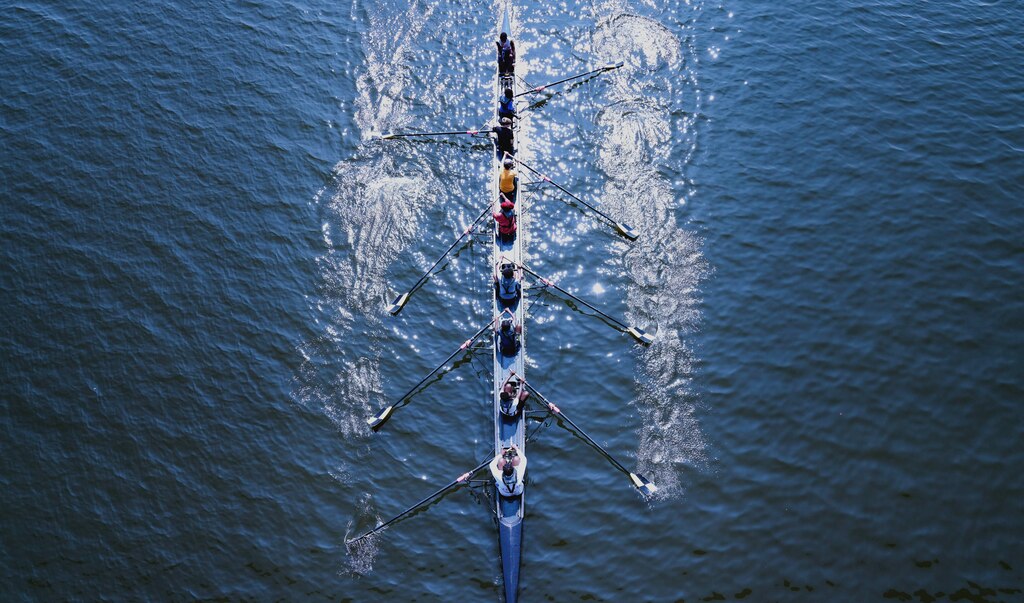 Kids from Restoring Inner Cities Hope paddle through the water on an 8 person boat with BCR instructors on Aug. 2, 2023.