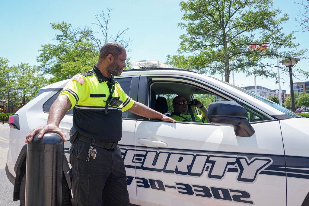 Sgt. Tony Vines speaks with Ofc. Billy Oaks inside of a security vehicle parked near the promenade outside the Mall in Columbia in Columbia, Md. on Monday, May 19, 2025.