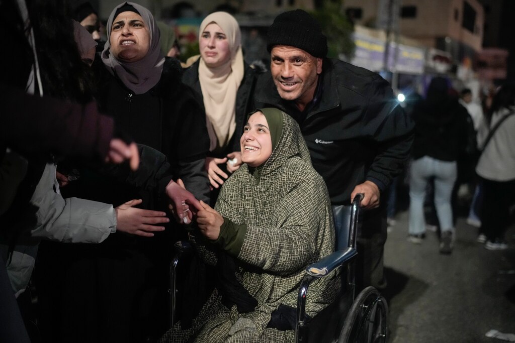 A female Palestinian prisoner on a wheelchair is greeted after disembarking from a bus following her release from an Israeli prison, in the West Bank city of Beitunia, early Monday, Jan. 20, 2025.