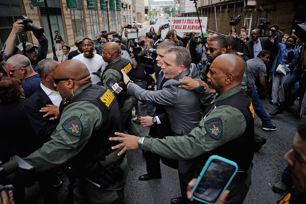 BALTIMORE, MD - MAY 23: Baltimore City Sheriff's Deputies surround and protect Baltimore Police Officer Edward Nero's family members as demonstrators and members of the news media crowd around outside the Mitchell Courthouse-West after Nero was found not guilty on all charges against him related to the arrest and death of Freddie Gray May 23, 2016 in Baltimore, Maryland. One of six police officers charged, Nero was found not guilty by Baltimore Circuit Judge Barry Williams in a bench trial.