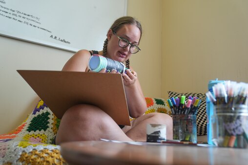 Gemma Frost takes some color pencils to work on her canvas at Make Studio in Baltimore, Md. on July 10, 2025. Frost says that she enjoys using a mix of mediums in her art.