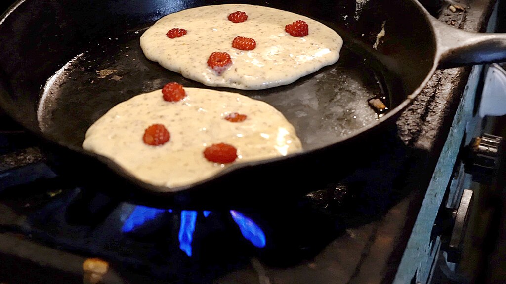 Pancakes make wineberries, a type of raspberry originally imported from Japan as an ornamental plant. The berries are jewel-bright, almost like red currants but with a deeper, red-wine color. They are very juicy and quite delicious.