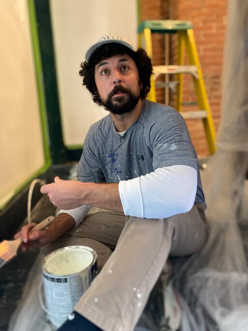 Reporter Tim Prudente applies finish on the wood floors of his Baltimore rowhome.