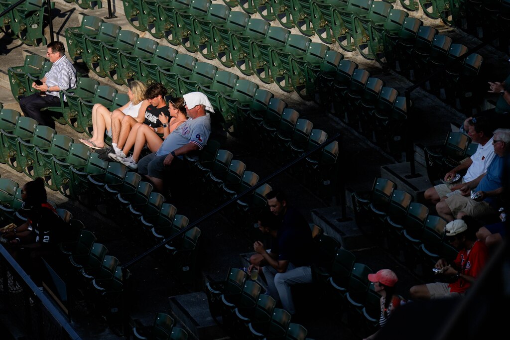 A Texas Rangers fan covers his head with a towel to stay cool during a game between the Baltimore Orioles and the Texas Rangers at Orioles Park at Camden Yards in Baltimore, Md. on Monday, June 23, 2025.