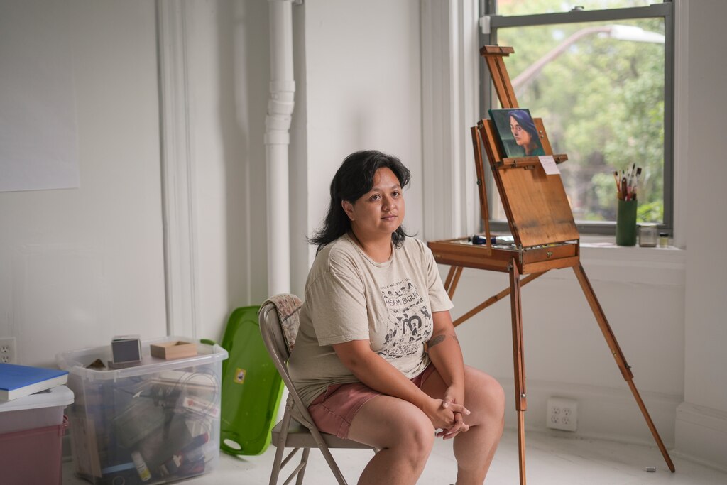 Chris Pasion, national coordinator of the Malaya Movement, sits next to an unfinished painting of hers in the group’s community center in Barclay, Baltimore on July 1, 2025. The Malaya Movement is a Filipino grassroots activist group.