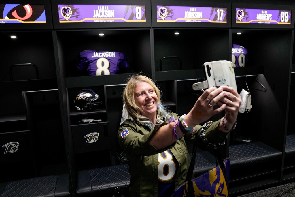 Courtney McDevitt takes a selfie in front of Lamar Jackson’s locker during a tour of the team’s locker room at A Purple Evening, the Baltimore Ravens’s annual women’s event, at M&T Bank Stadium in Baltimore on Monday, October 14, 2024.