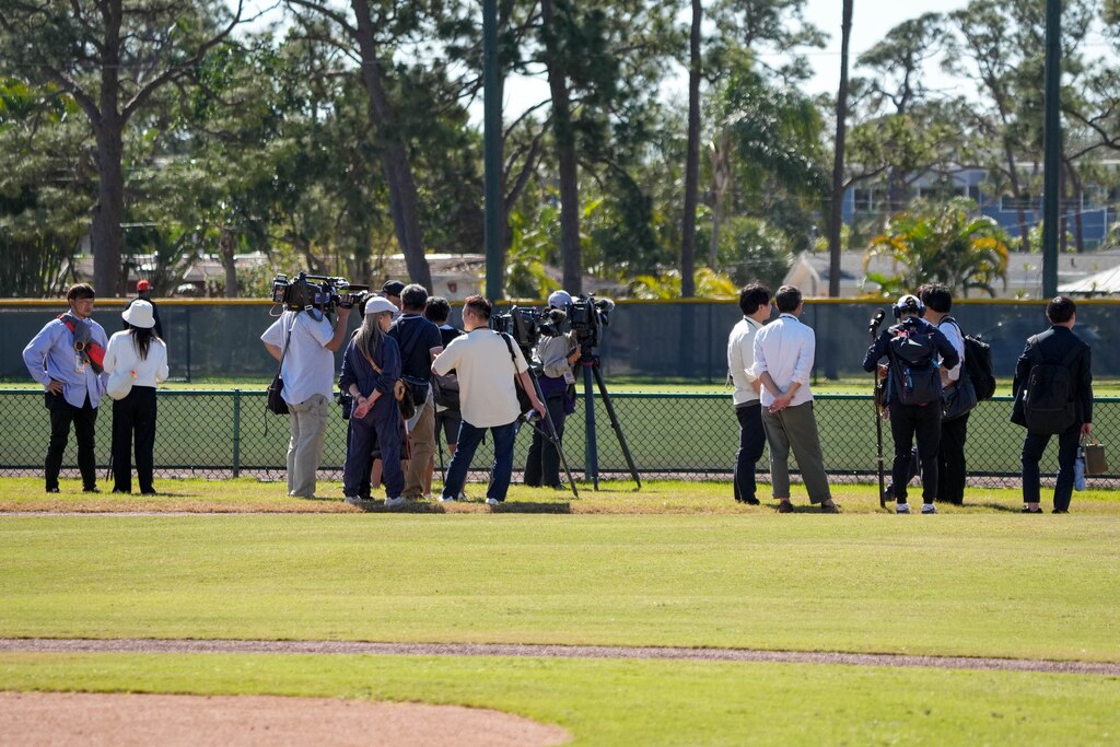 Journalists with various Japanese news outlets document newly signed Baltimore Orioles pitcher Tomoyuki Sugano as he warms up with the team during Spring Training at Ed Smith Stadium in Sarasota, Fla. on Sunday, February 23, 2025.
