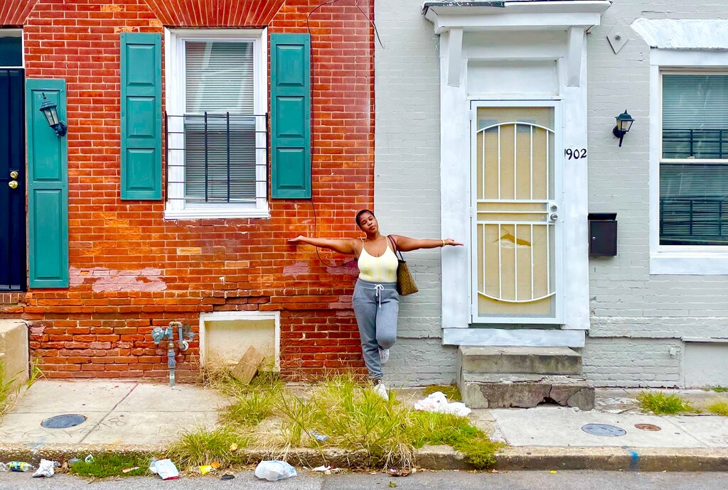 Leslie E. Redmond stands in front of two of her properties in Carrollton Ridge, a southwest Baltimore neighborhood. One of the row homes will be used to house veterans and the other will house a single mom.