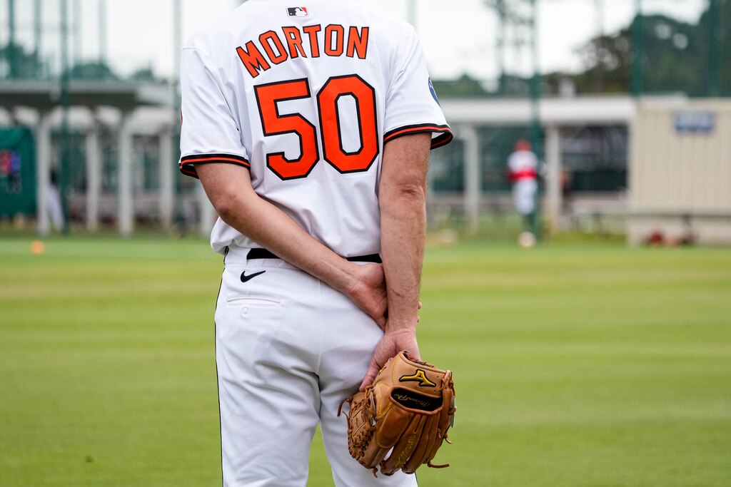 Baltimore Orioles pitcher Charlie Morton (50) holds his glove behind his back as he observes teammates warming up during Spring Training at Ed Smith Stadium in Sarasota, Fla. on Saturday, February 22, 2025.