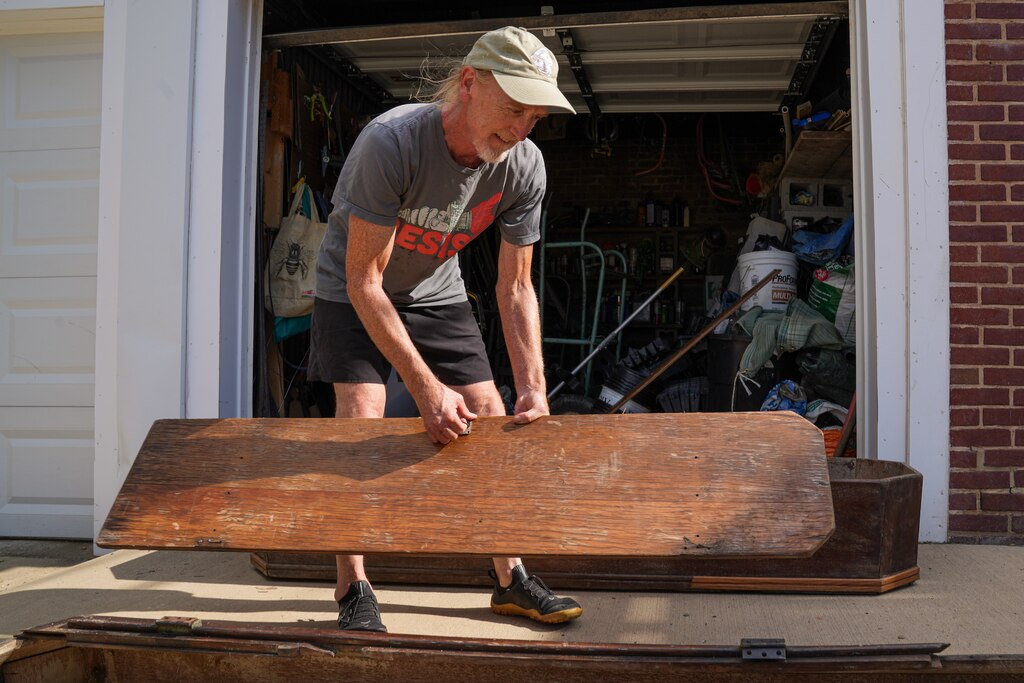 Artist Ashley Kidner brings all of the pieces of Mathilda Lorenz’s empty casket to the outside of his garage on July 28, 2022. The mysterious casket was originally found down by a stream in Wyman Park.