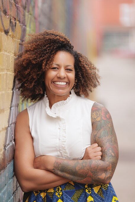 Headshot of Jen Fry leaning against a brick wall.