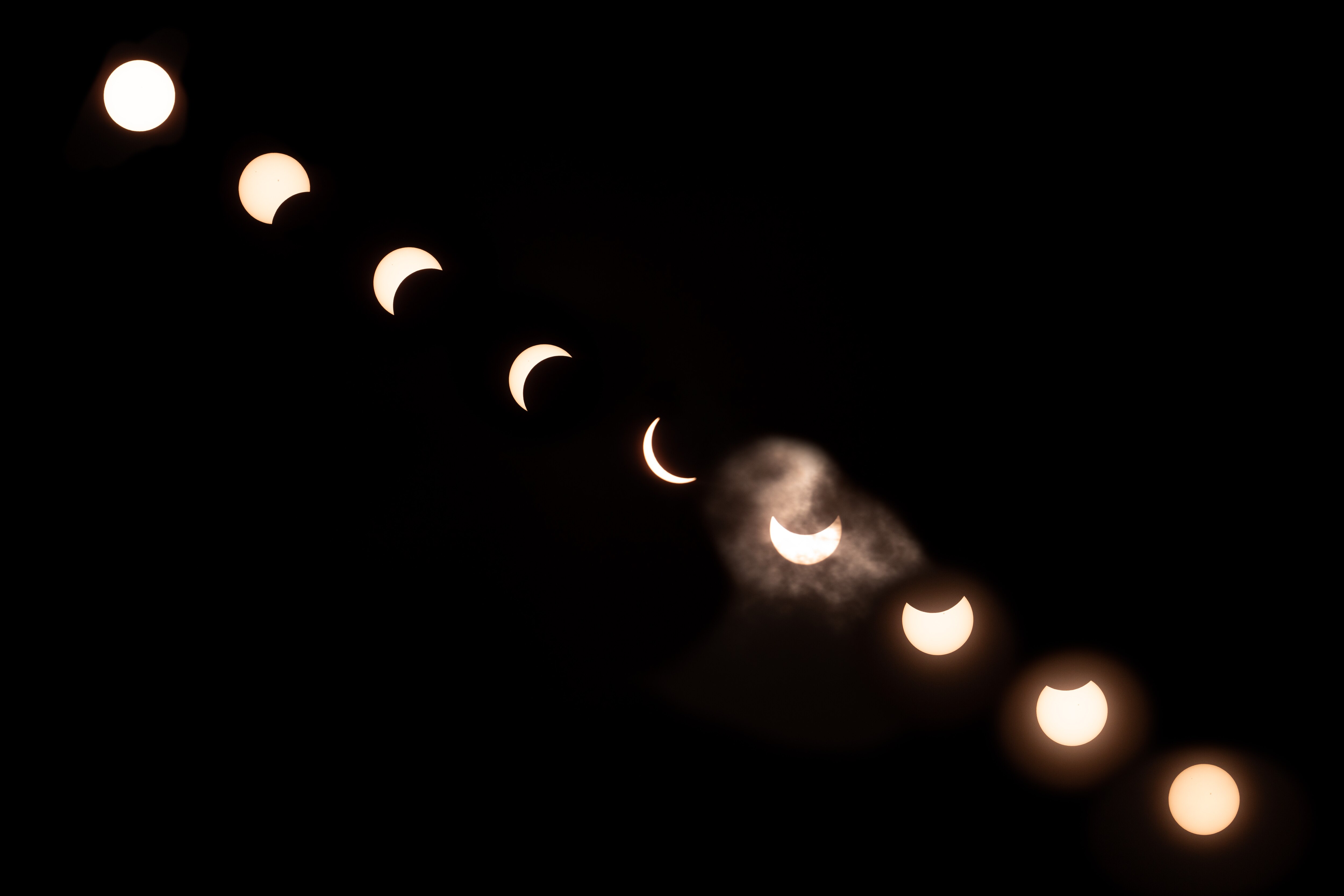 A composite image made from several images of the various stages of the lunar eclipse on April 8, 2024. Photographer Eric Thompson created this image by assembling a solar filter for his camera lens with cardboard, solar sheets, and gaffer's tape. The eclipse was viewed from Patterson Park.