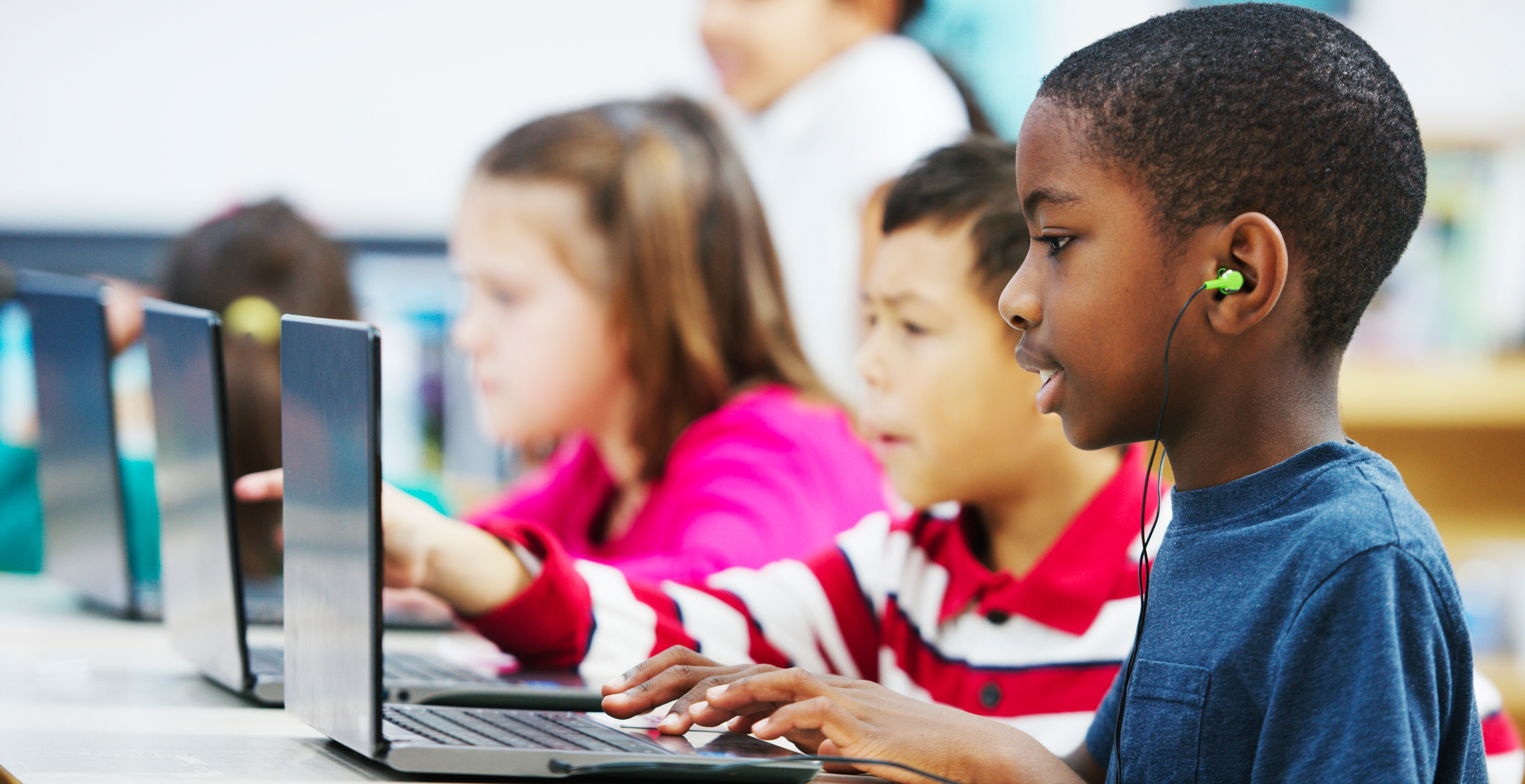 A little boy takes a standardized test on a laptop.