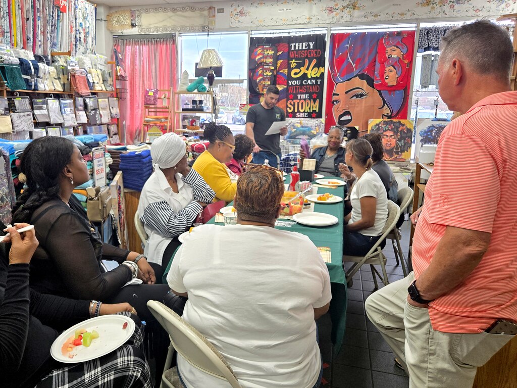 Jason Gaister, standing center, reads a letter to the staff of Linen World announcing that the store is closing after 37 years in Oxon Hill.