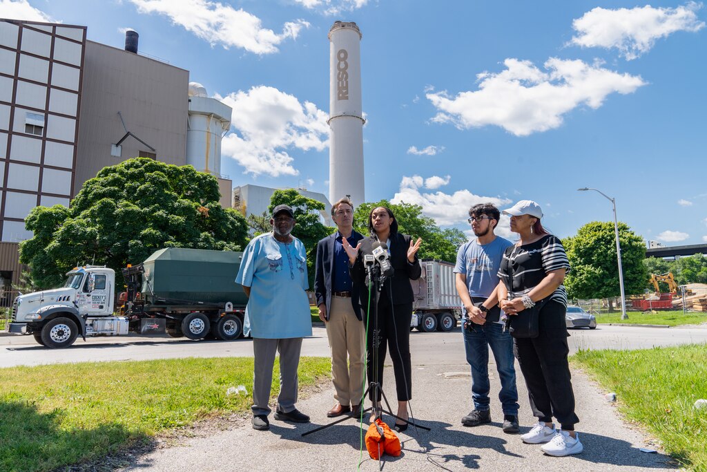 Attorney Taylor Lilley of the Chesapeake Bay Foundation, center, speaks during a press conference announcing a civil rights complaint filed to the EPA about the RESCO trash incinerator on May 29, 2024.