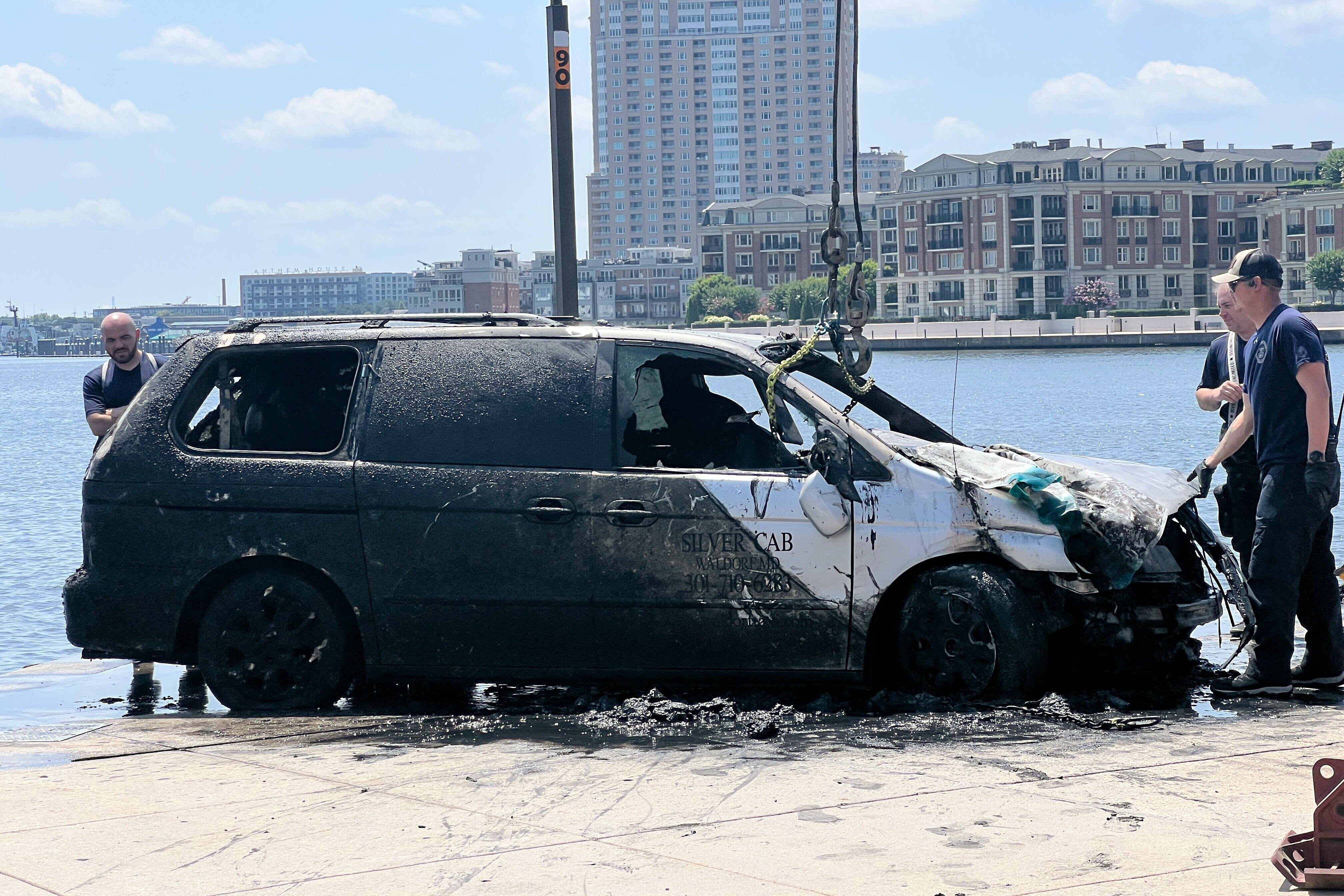 Baltimore City Fire and the Baltimore City Police Underwater Recovery Team work to pull a Silver Cab from the Inner Harbor on Thursday, July 24, 2025.